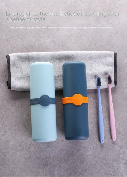 Two travel-sized toothbrush cases with a towel and toothbrushes on a gray surface.