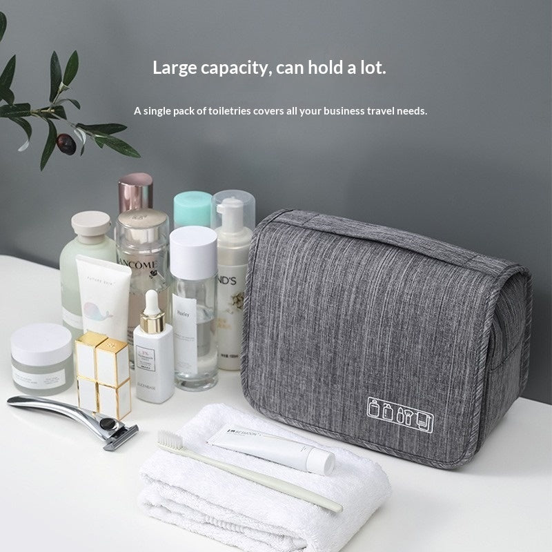 Gray toiletry bag with travel essentials on a white surface with a gray background