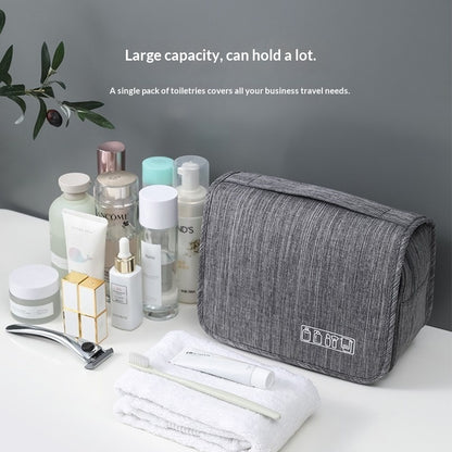Gray toiletry bag with travel essentials on a white surface with a gray background