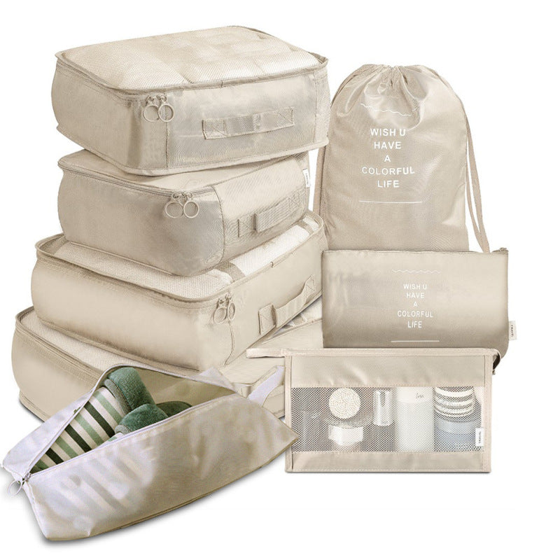 Set of beige travel packing cubes with various compartments on a white background
