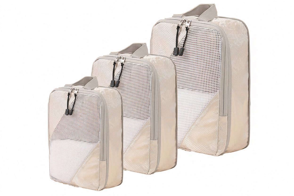 Set of three beige packing cubes of various sizes with mesh sections on a white background